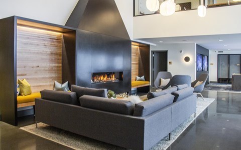A modern living room with a grey sofa and a fireplace.