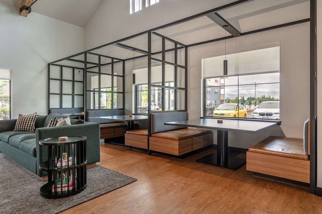 a living room with a couch and a desk and a window