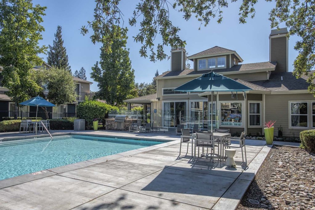 Swimming Pool Area With Shaded Table And Chairs at Atwood Apartments, Citrus Heights, CA