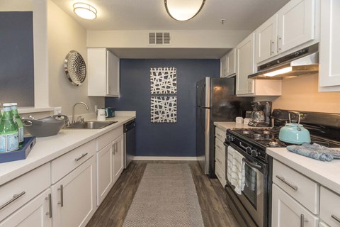 a kitchen with white cabinets and a stove and refrigerator