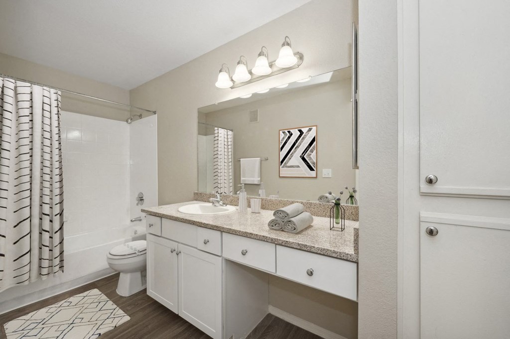 a bathroom with a large mirror and a shower and a toilet