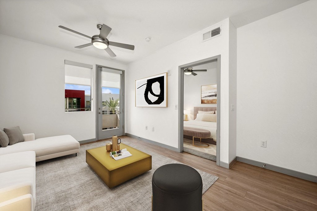 a living room with white walls and a ceiling fan