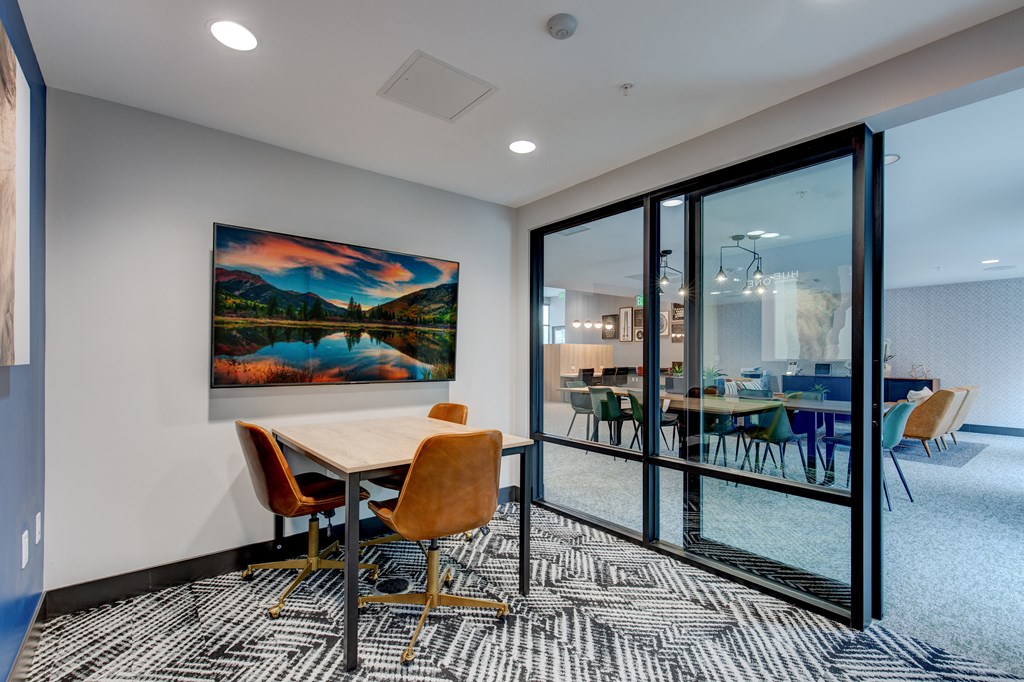 a conference room with glass doors and a table with chairs