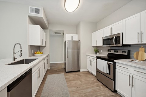 a kitchen with white cabinets and stainless steel appliances