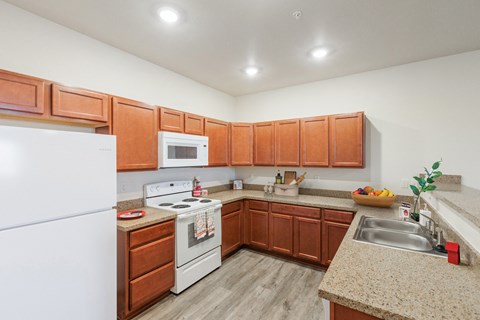 a kitchen with wood cabinets and white appliances and granite counter tops