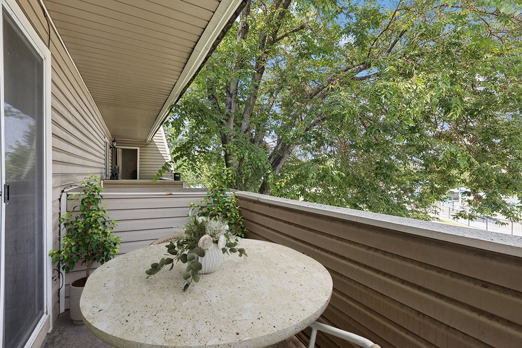 a patio with a table and a vase of flowers on it