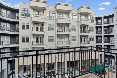 Apartment building with balconies and a pool.
