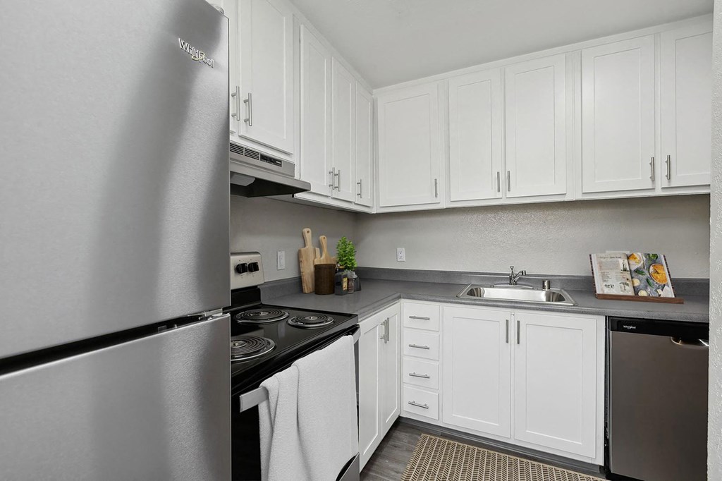 a kitchen with stainless steel appliances and white cabinets