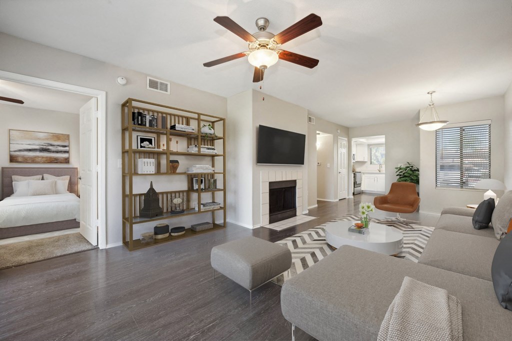 a living room with a fireplace and a ceiling fan