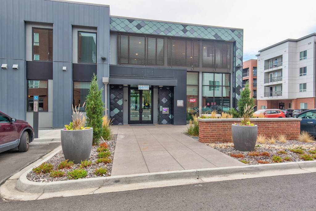 the front of a building with a sidewalk and planters