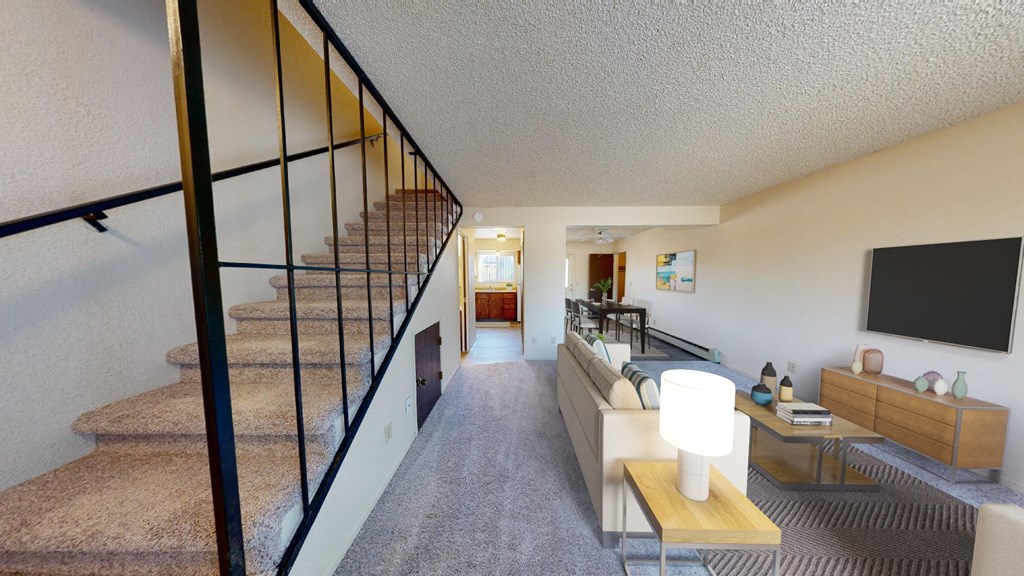 a living room with a staircase and a tv