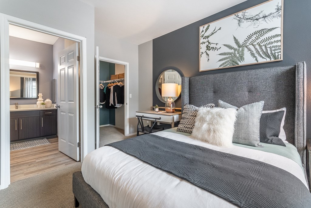 a bedroom with a large bed and a door to a bathroom