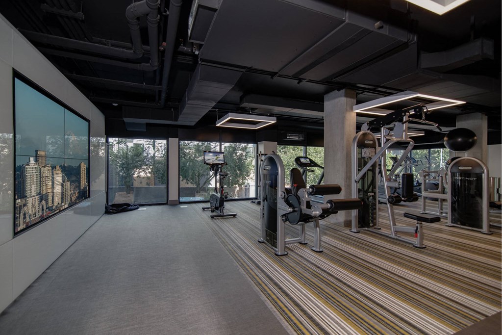 a rendering of a fitness room with weights machines and a large window