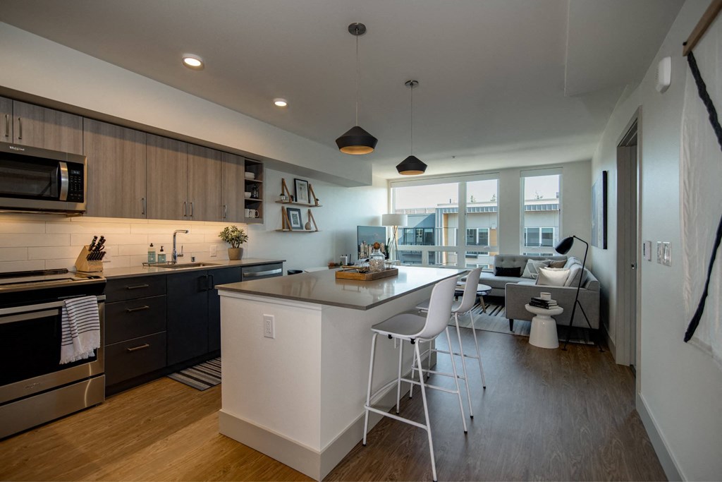 a kitchen and living room with an island and stools