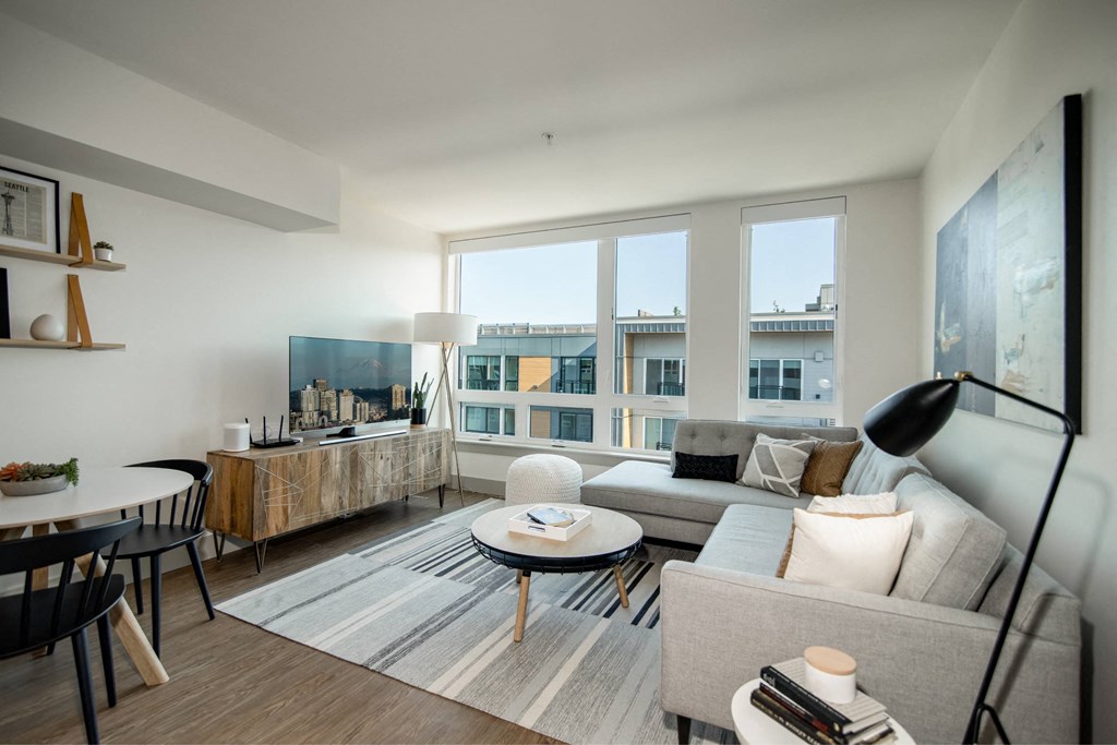 a living room with couches and tables and a large window