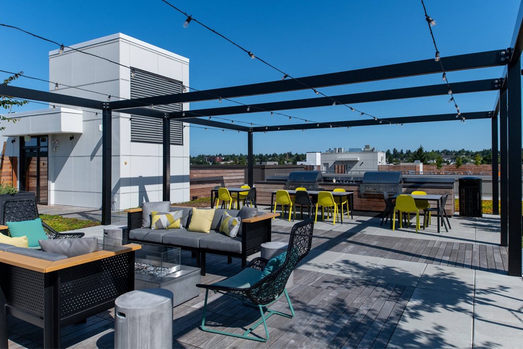 a rooftop patio with tables and chairs and a canopy