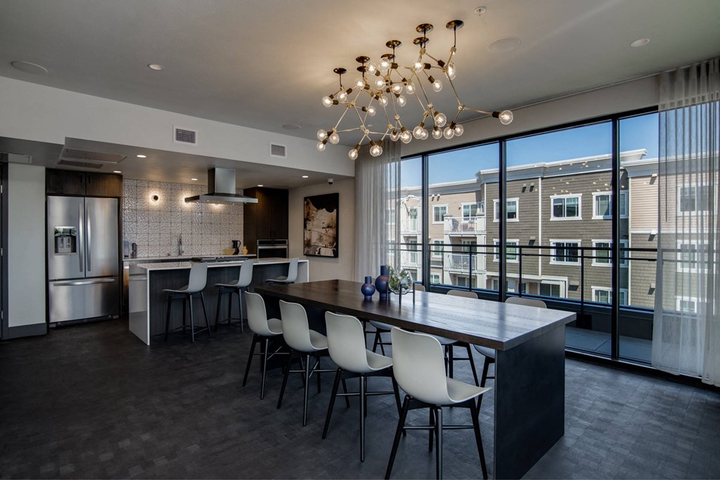 a kitchen with a large island with chairs and a large window