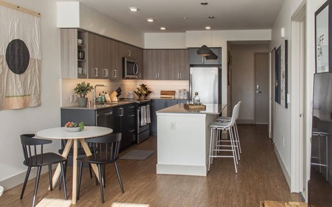 a view of a kitchen and a dining room with a table and chairs
