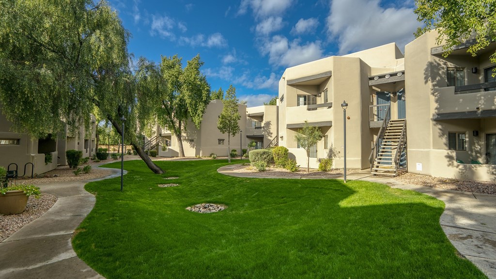an apartment building with green grass and trees