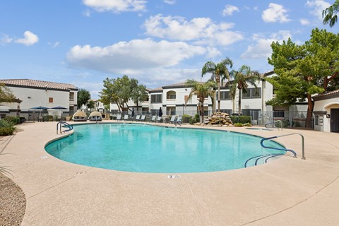 A swimming pool surrounded by palm trees and buildings.