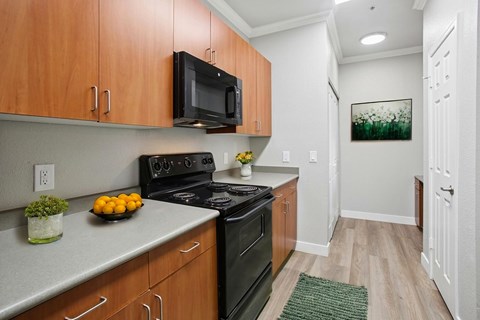A kitchen with wooden cabinets and a black stove top oven.
