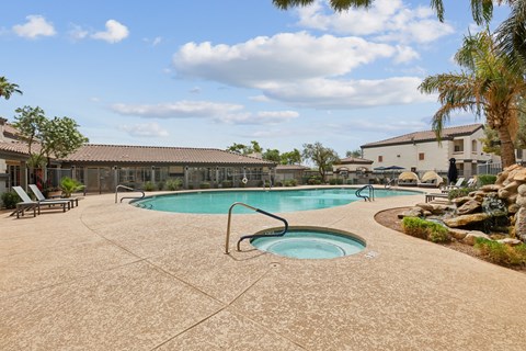 A large outdoor swimming pool with a hot tub in the middle.