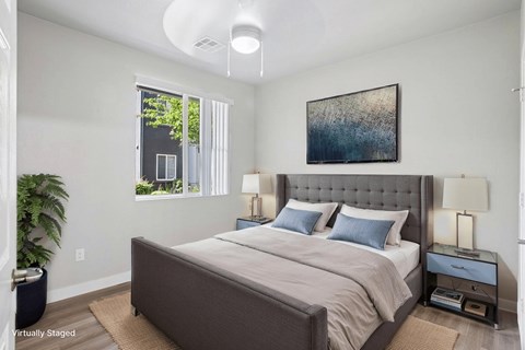 A bedroom with a large bed and a painting on the wall.