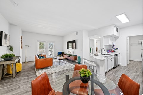 A modern living room with a dining table and chairs.