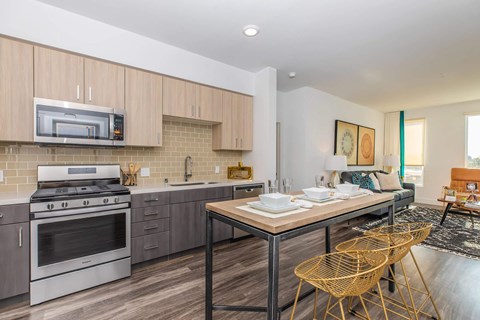 a kitchen with stainless steel appliances and a table with chairs
