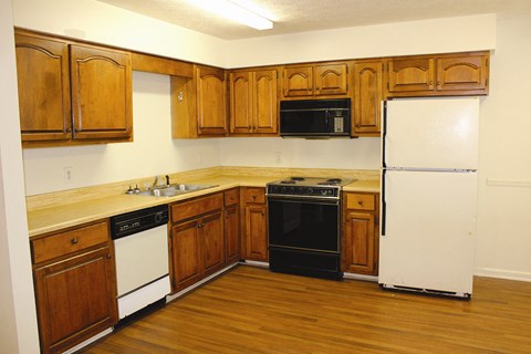 a kitchen with wooden cabinets and appliances and a white refrigerator