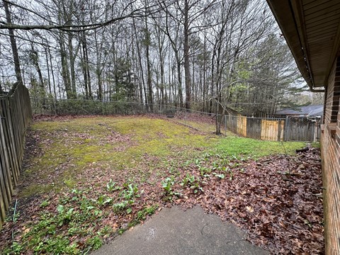 the backyard of a house with a yard and a fence