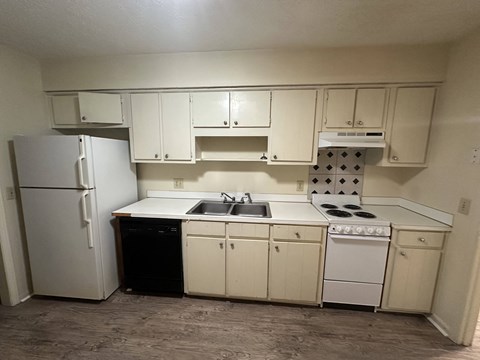 A kitchen with white cabinets and appliances.