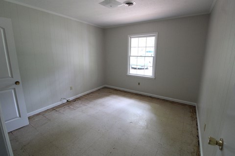 an empty room with white walls and a window
