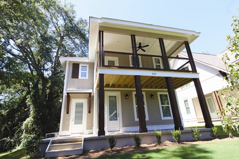 the front of a white house with a covered porch
