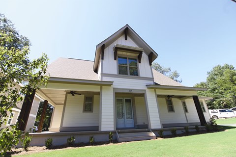 a white house with a green lawn and a blue sky