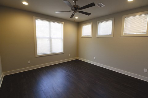 a living room with wood floors and a ceiling fan