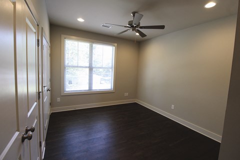 an empty room with a ceiling fan and a window
