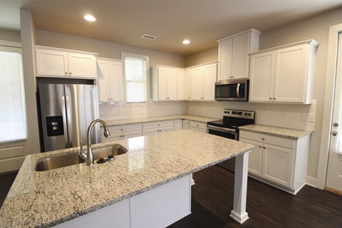 a kitchen with white cabinets and a granite counter top
