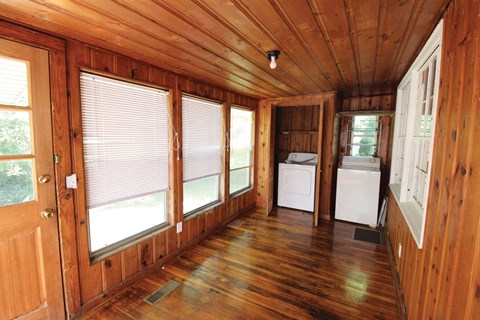 a small room with wood floors and a kitchen