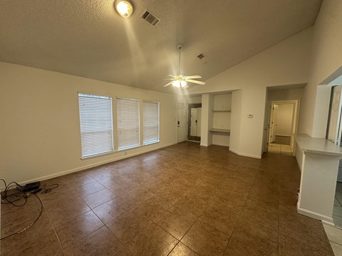 A room with a ceiling fan and tiled floor.