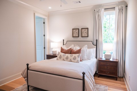 A bedroom with a large bed and a window with curtains.