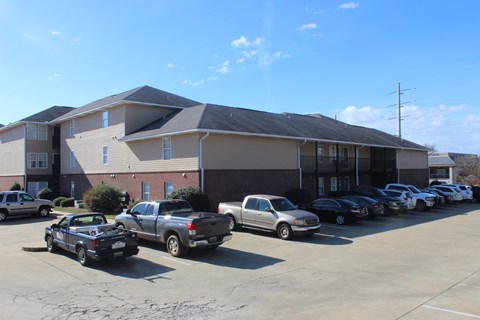 the front of a building with cars parked in a parking lot
