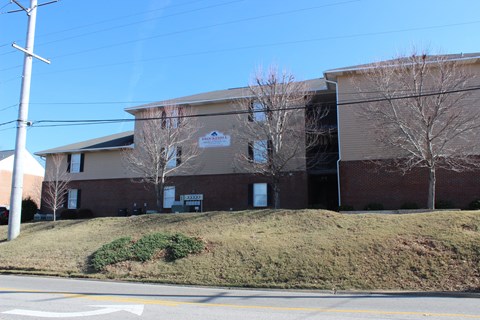 a large brick building with a hill in front of it