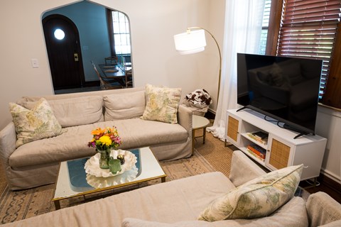 A living room with a couch, a coffee table, and a television.
