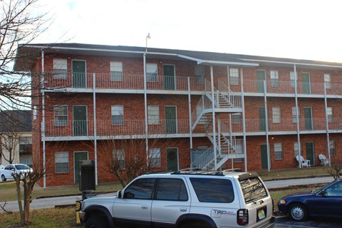 an apartment building with cars parked in front of it
