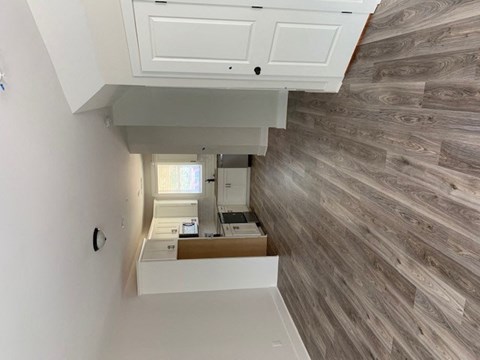 a view of a kitchen from the top of the stairs