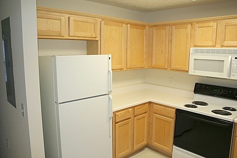 A kitchen with wooden cabinets and white appliances.