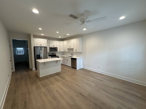 A kitchen with a refrigerator, microwave, and oven.