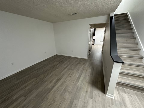A room with a staircase and wooden flooring.
