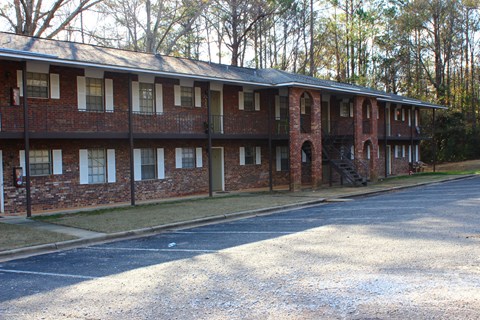 the front of a brick building with a parking lot